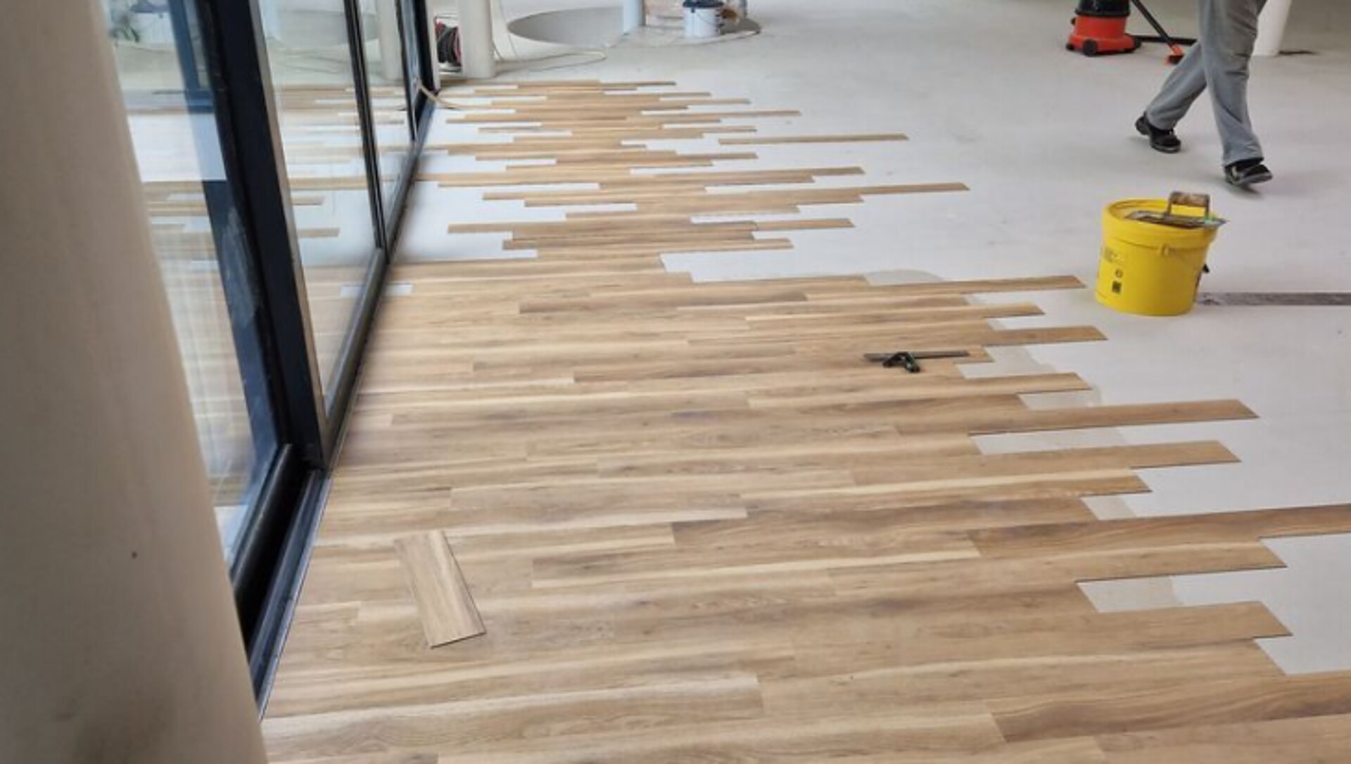 Wood-effect LVT planks being laid by Holmes Interior Flooring — real job in progress